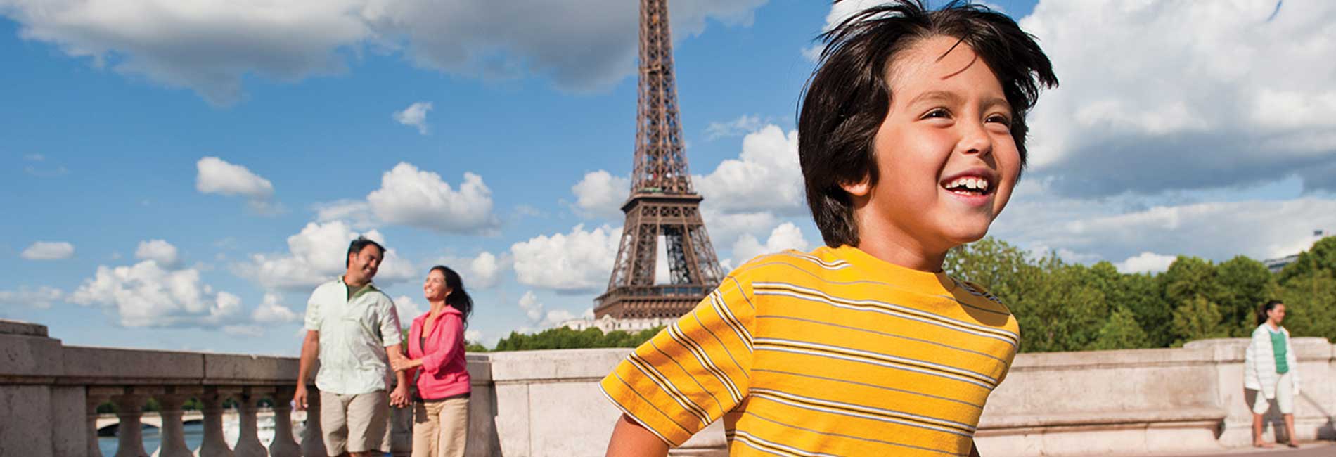 Little boy running in front of the Eiffel Tower in Paris, France